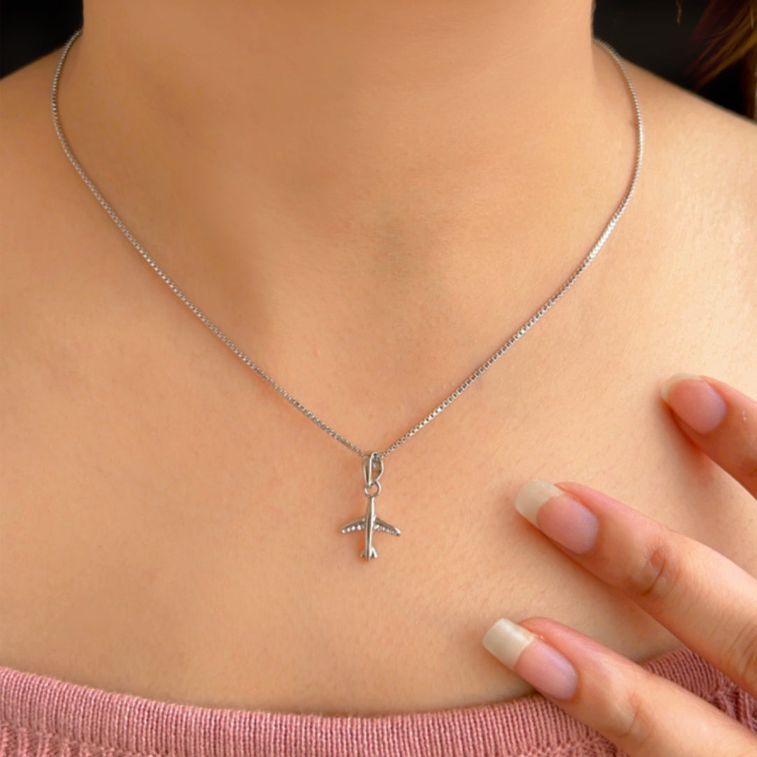 A Model Wearing a beautiful silver pendant in the shape of aeroplane for you to have a better idea of the size of the pendant. .