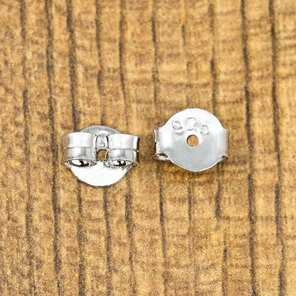 Shiny silver earring push backs designed to hold stud earrings in place.